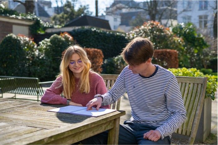Student helpt een leerling met huiswerk